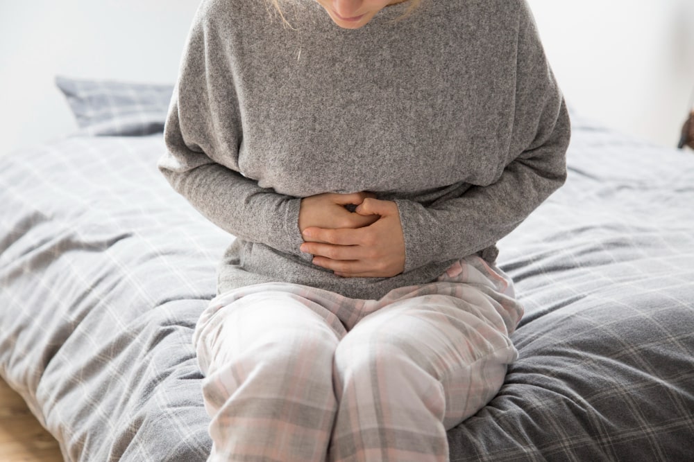 sick-woman-with-hands-stomach-suffering-from-intense-pain-min